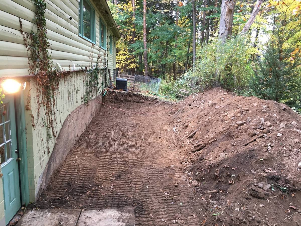 Same side yard cleared and graded flat down to the block foundation wall