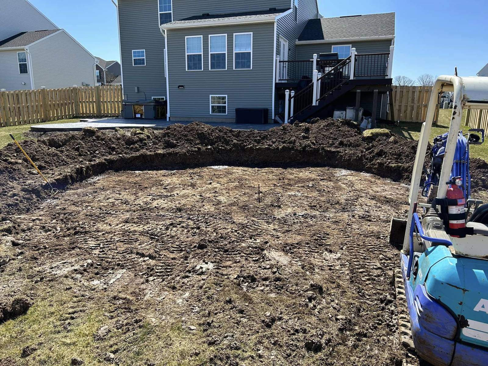Backyard excavated and graded for an above-ground pool, mini excavator on site, Monroe County NY