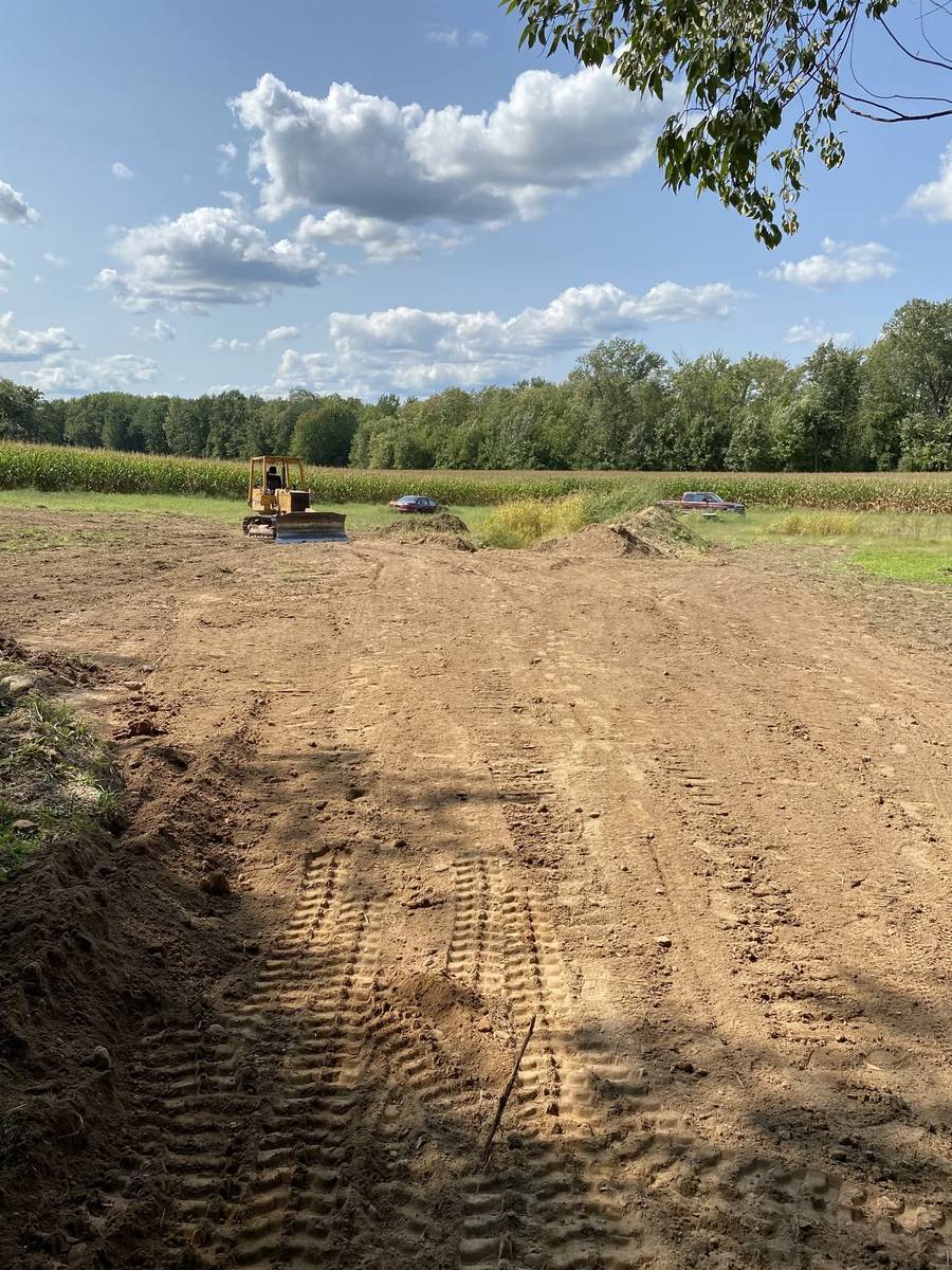 Bulldozer grading a level pad on open ground for site preparation